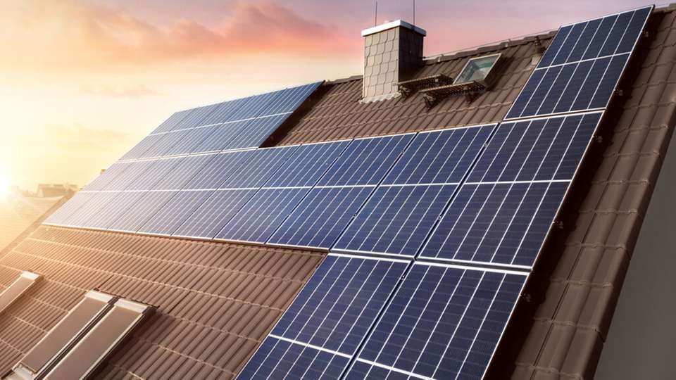 Photovoltaikmodule auf einem Hausdach bei Abendsonne